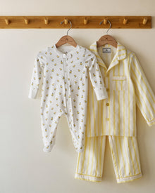 The Baby's Pima Romper in Tres Chick is a white, long-sleeve onesie with a yellow duckling print, footed bottoms, folded cuffs, and a zipper running from the collar to one leg.