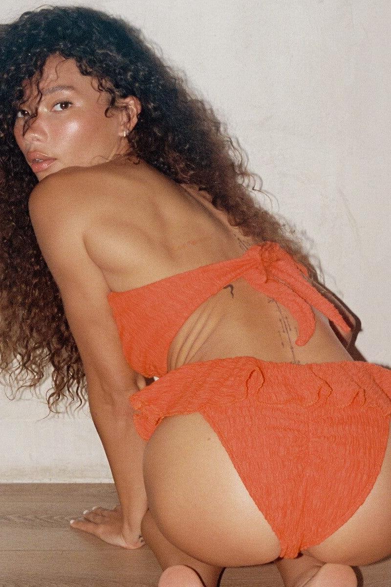 Tangerine textured bandeau bikini top with tie straps, displayed on model.
