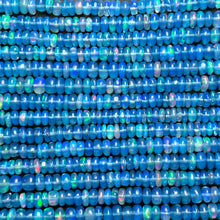 Shimmering beaded opal necklace made of smooth opals in shades of blue on a gold slim lobster clasp styled as a swatch