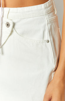 Close-up of the white denim asymmetrical wrap mini skirt with a front pocket and button detail