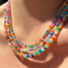 Multi-colored opal necklaces layered on the neck.