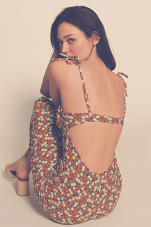 Long slip dress with multicolored floral print, thin shoulder straps, and open back design.