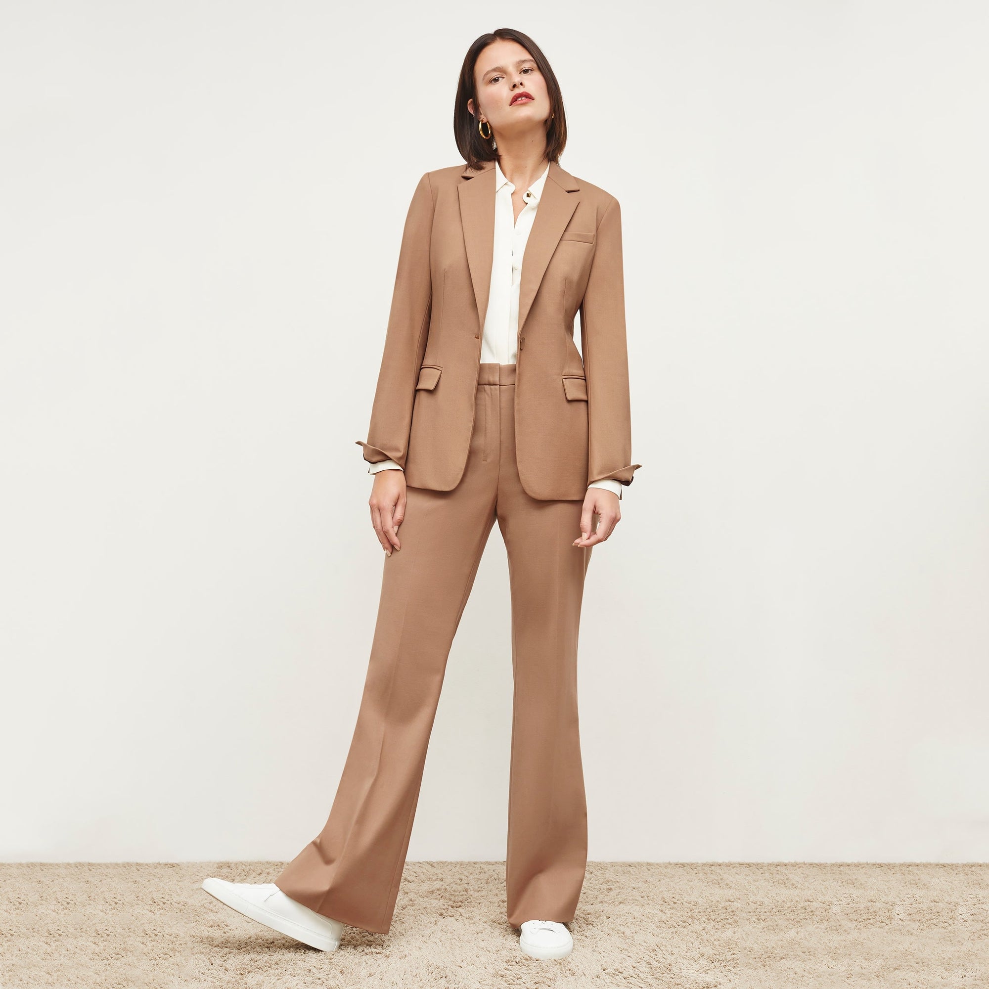 Front image of a woman standing wearing the Yiyan Blazer in Camel | Exclude