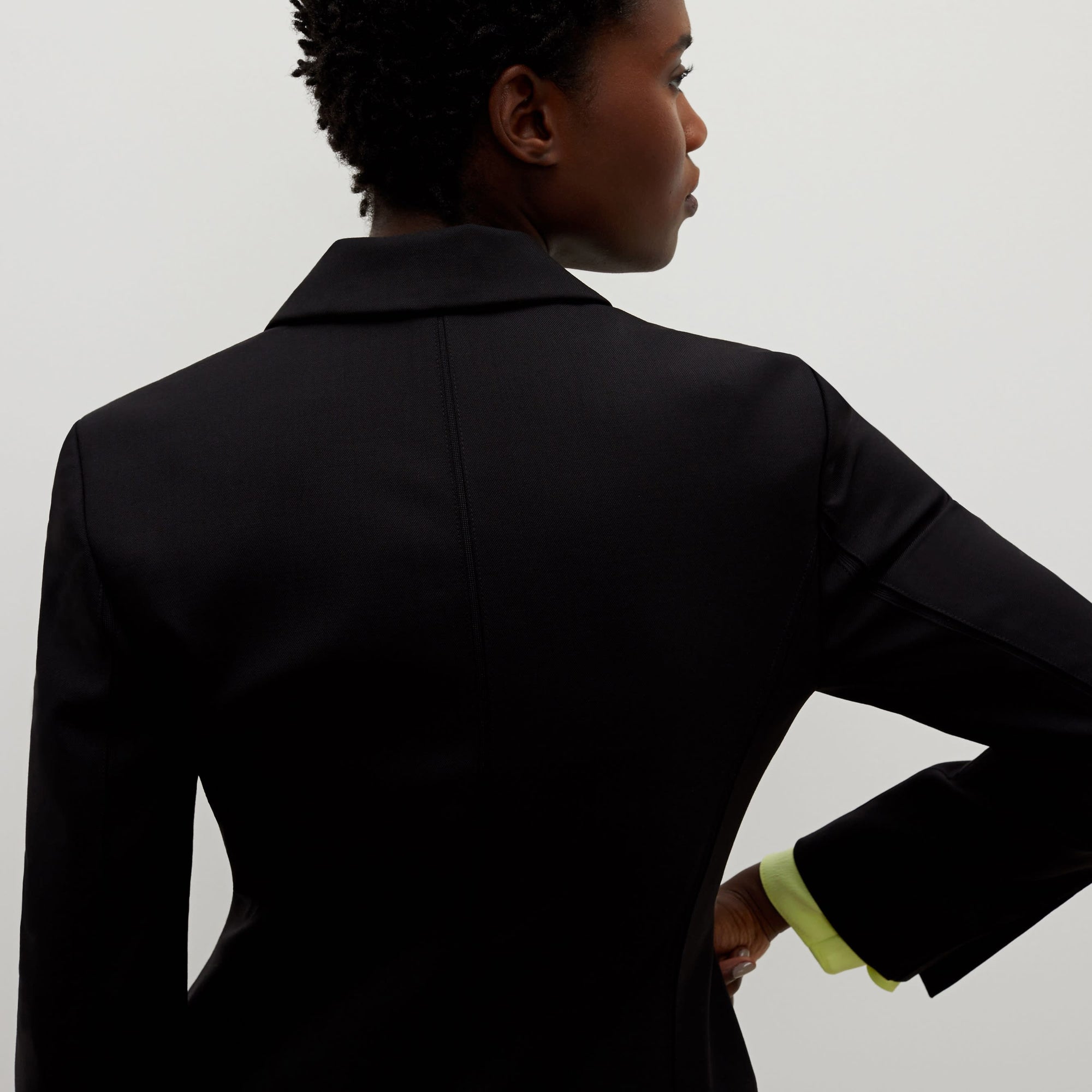 Back image of a woman standing wearing the bennett blazer wool twill in black