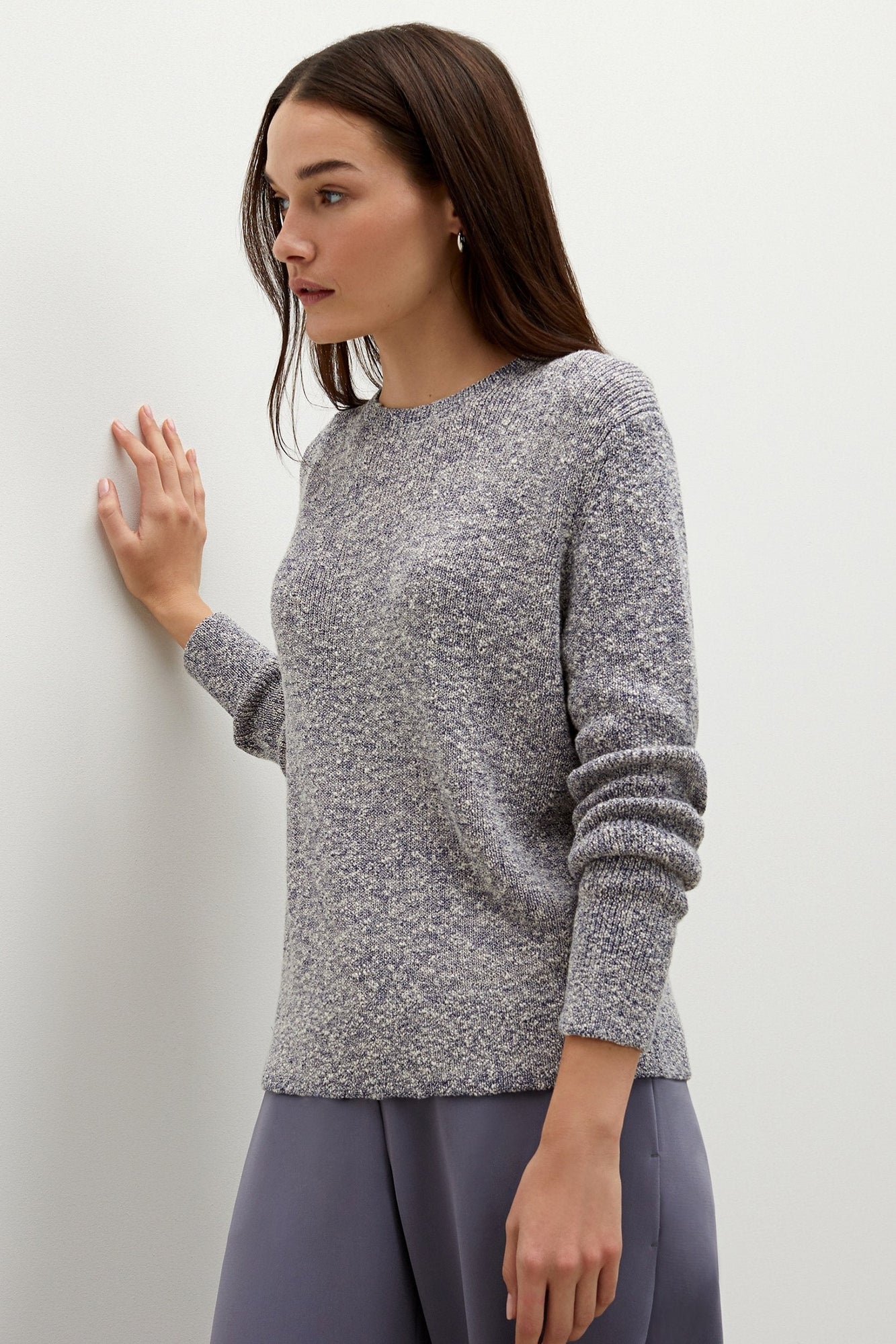 Side image of a woman standing wearing the butler top knit boucle in navy | Exclude