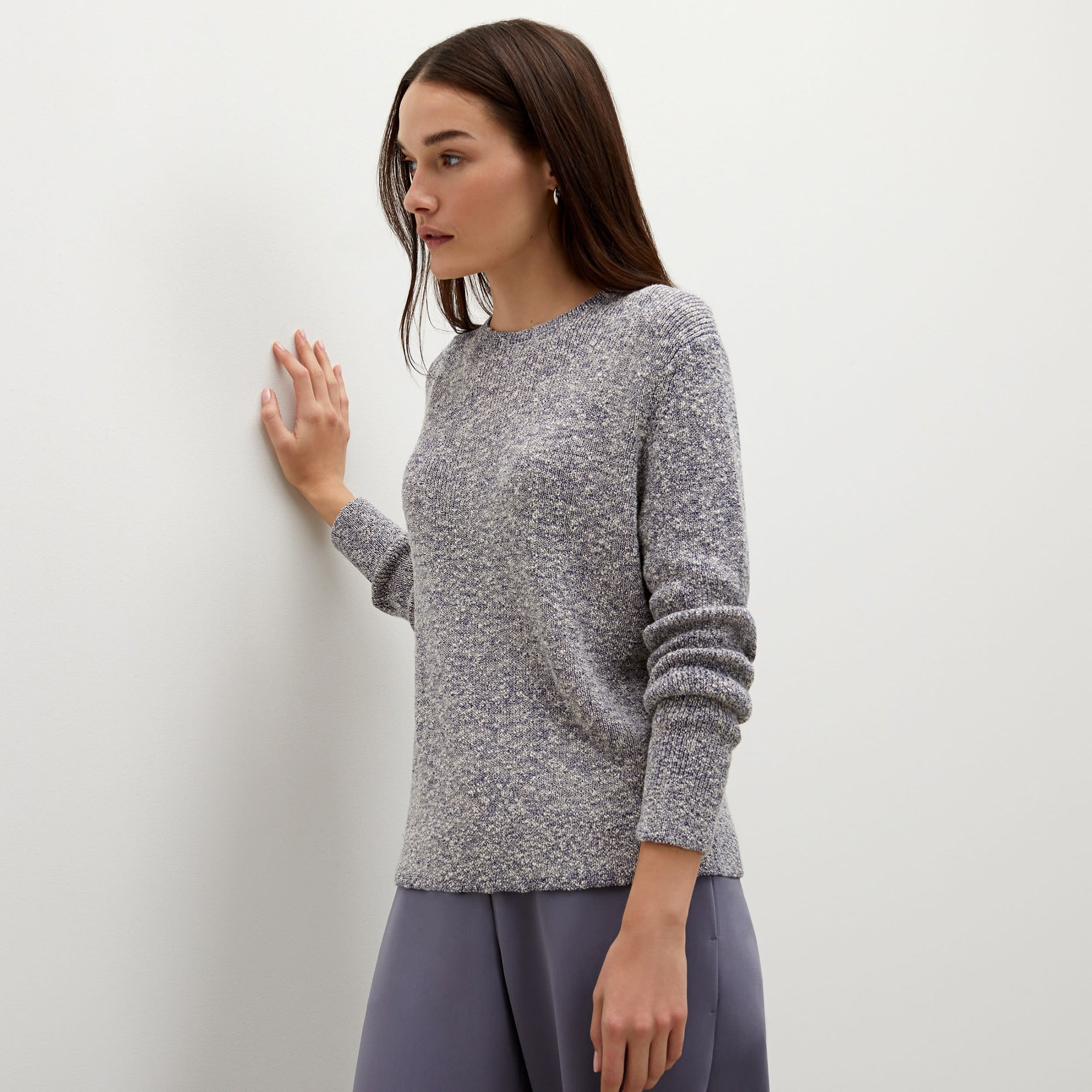 Side image of a woman standing wearing the butler top knit boucle in navy