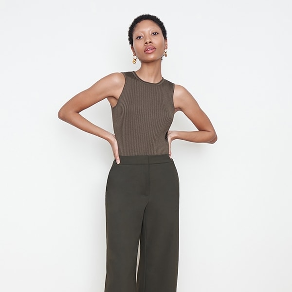 Front image of a woman standing wearing the avery top in safari | Exclude