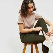 Detail image of a woman standing wearing the curie pant in dark olive