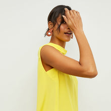 Side image of a woman standing wearing the Daisy Top—Washable Silk in Sunshine | Exclude
