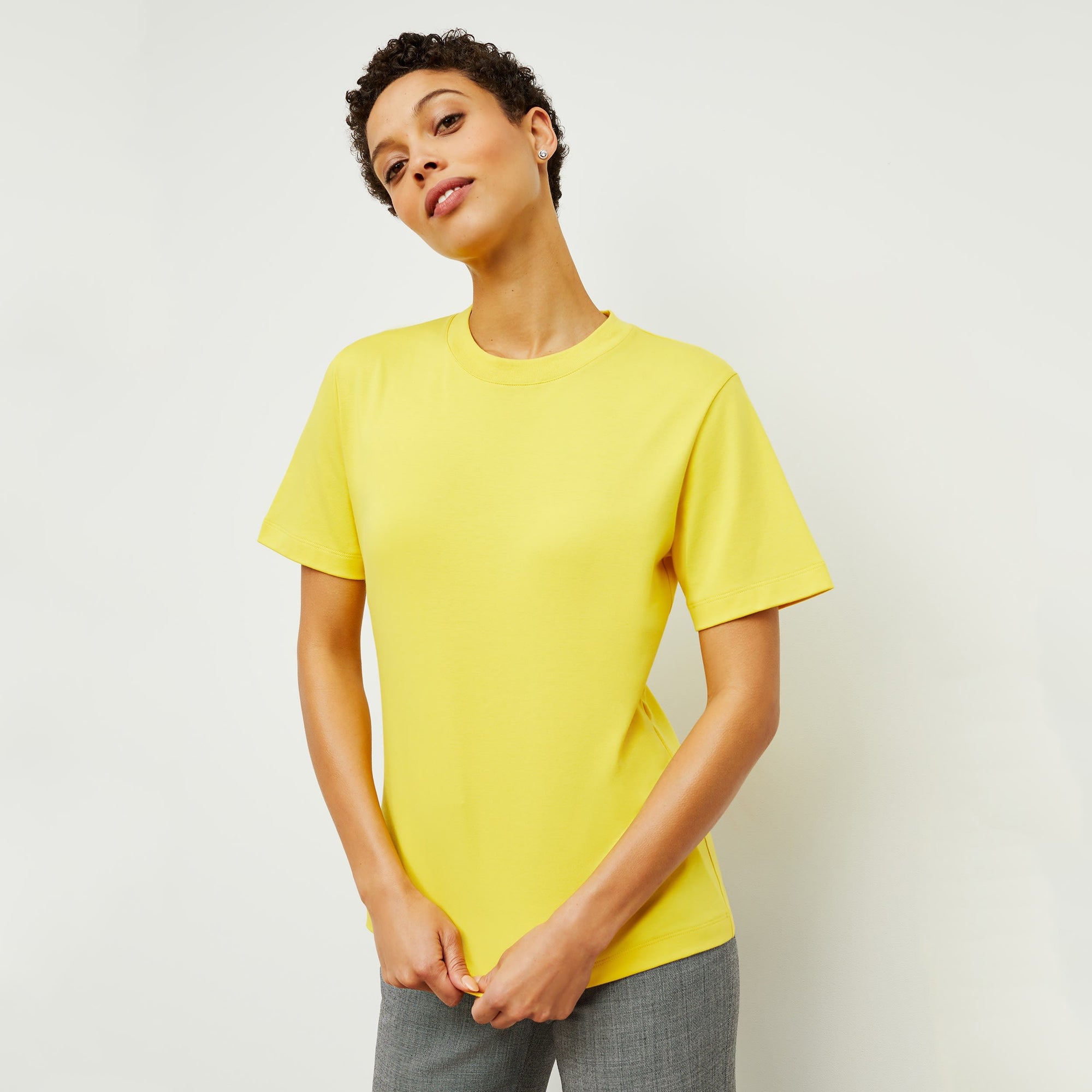 Front image of a woman standing wearing the Leslie T-Shirt—Compact Cotton in Sunshine