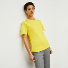 Front image of a woman standing wearing the Leslie T-Shirt—Compact Cotton in Sunshine