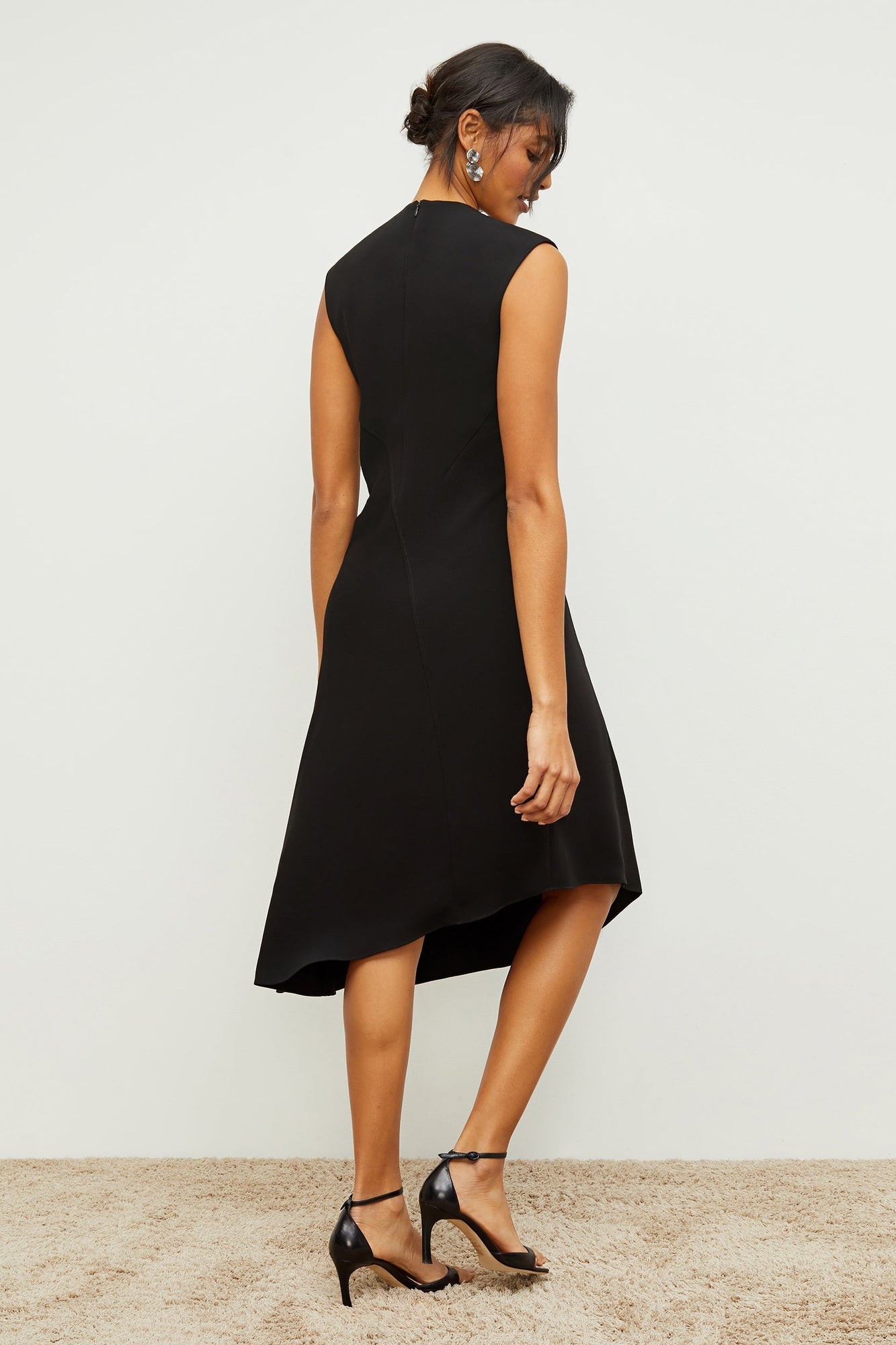 Back image of a woman standing wearing the Lara Dress in Black | Grid Hover | Exclude