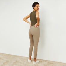 Back image of a woman standing wearing the avery top in safari