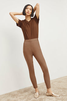 Front image of a woman standing wearing the Curie Pant—Everstretch in Saddle | Exclude