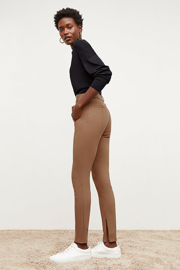 Side image of a woman standing wearing the Curie Pant—Everstretch in Saddle | Exclude