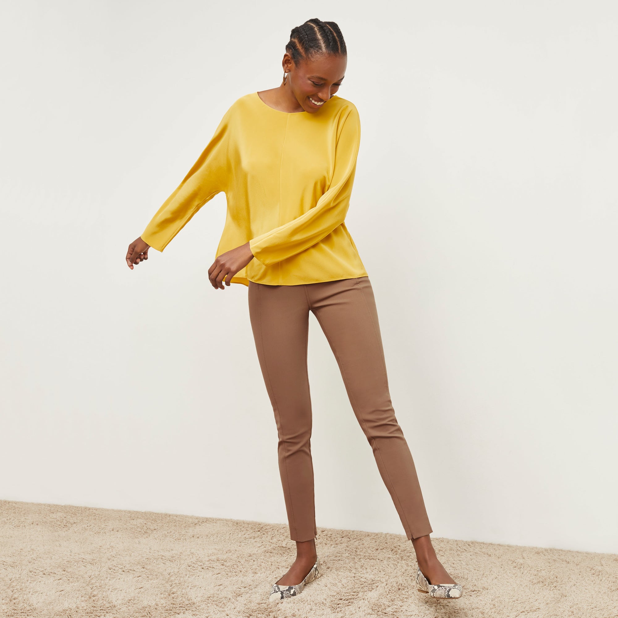 Front image of a woman standing wearing the Curie Pant—Everstretch in Saddle | Exclude