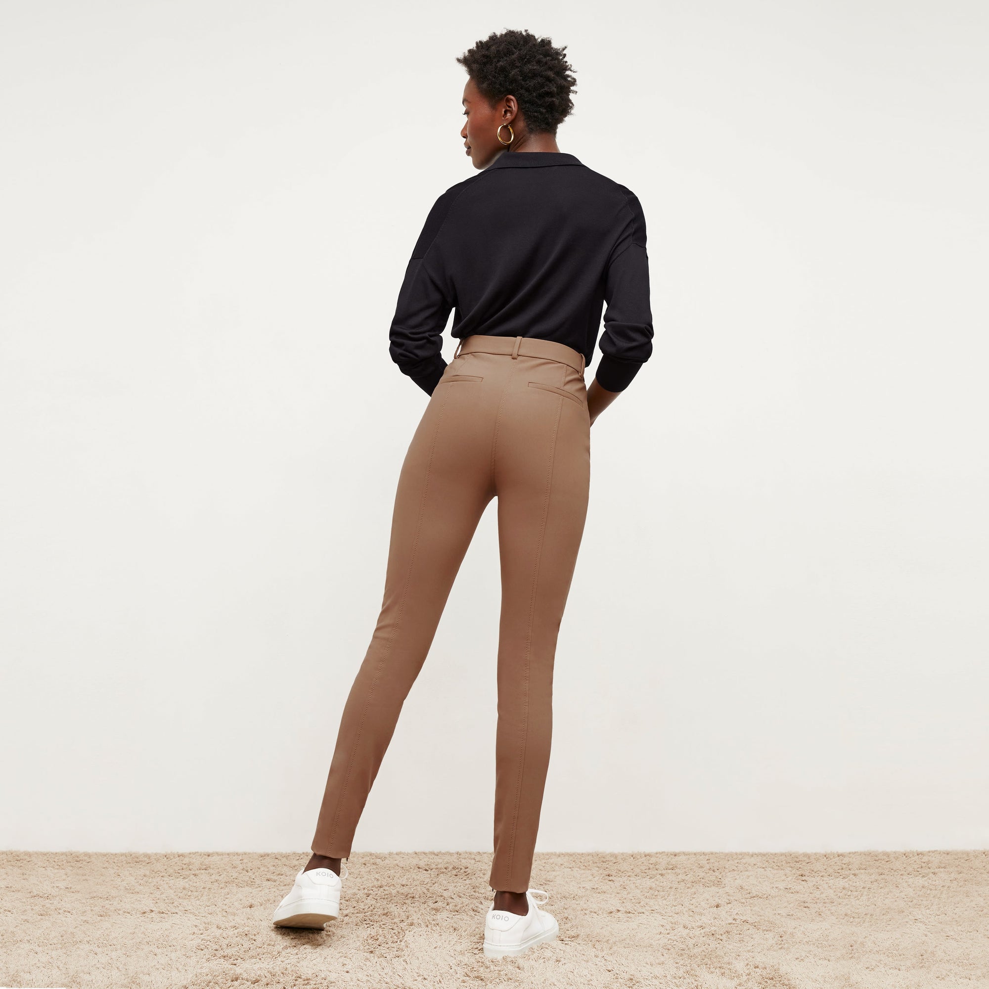 Back image of a woman standing wearing the Curie Pant—Everstretch in Saddle