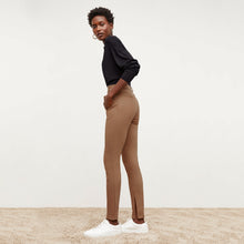 Side image of a woman standing wearing the Curie Pant—Everstretch in Saddle | Exclude