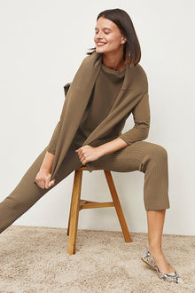 Front image of a woman standing wearing the Finley Legging—Ribbed Jardigan Knit in Light Bronze | Grid | Exclude