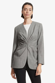 Front image of a woman standing wearing the Carmen jacket sharkskin in Black and white | Grid | Exclude