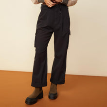 Front view of model in the utility wide leg pants in black.