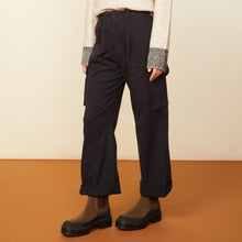 Side view of model in the utility wide leg pants in black.