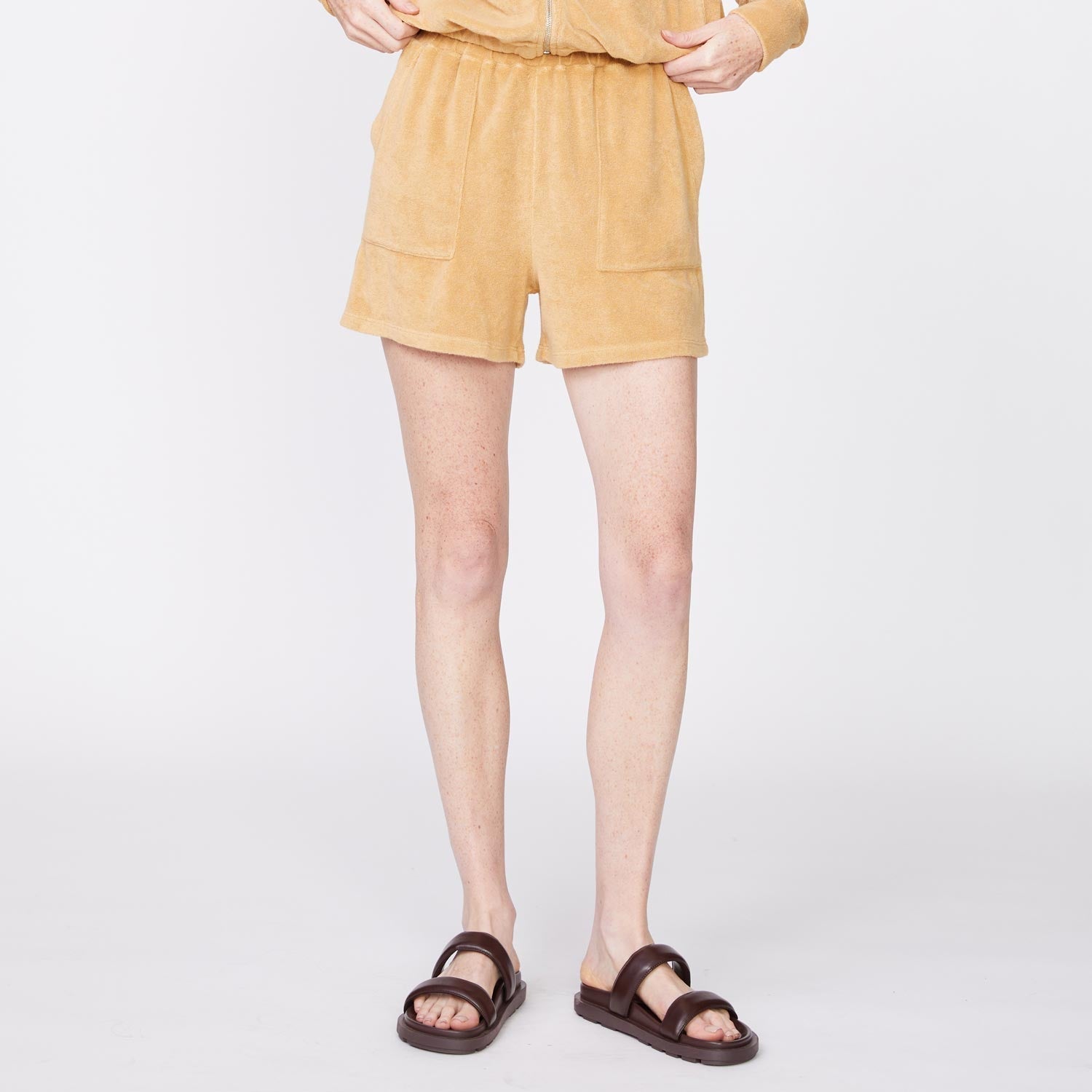 Front view of model wearing the terry cloth shorts in irish cream.