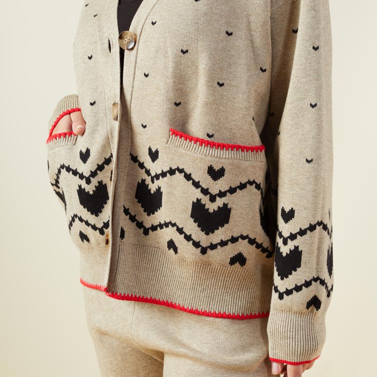 Close up view of model wearing the supersoft sweater knit heart fair isle cardigan in oatmeal.