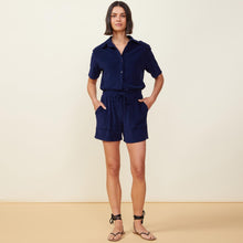Front view of model wearing the terry cloth romper in navy.