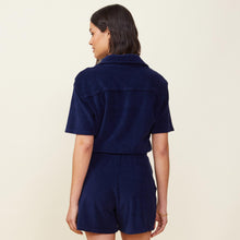 Back view of model wearing the terry cloth romper in navy.