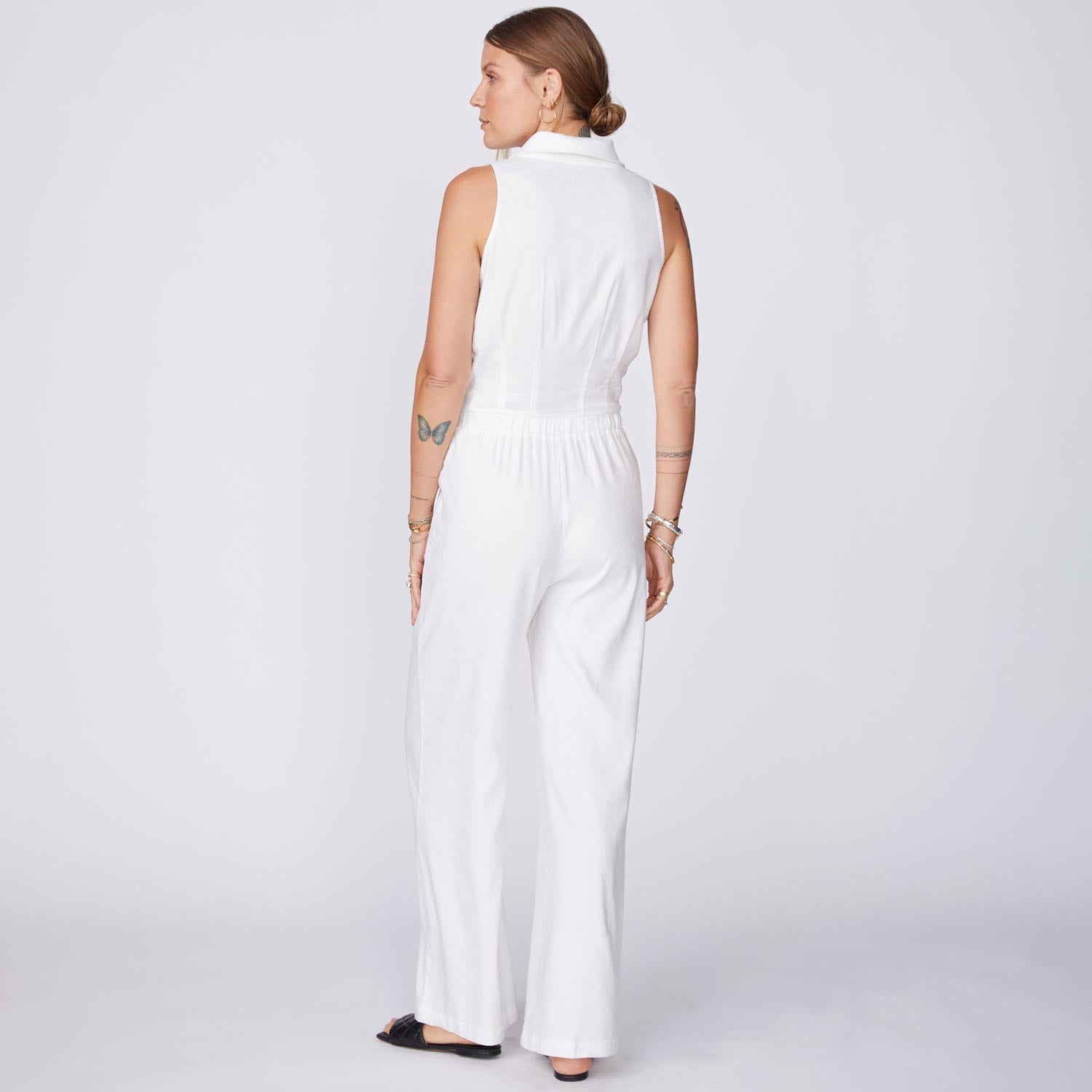 Back View of model wearing the Linen Halter Polo Jumpsuit in White