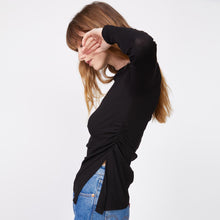 Side view of model wearing the needle rib slit long sleeve in black.