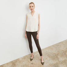 Front image of a woman standing wearing the curie pant in dark olive | Exclude