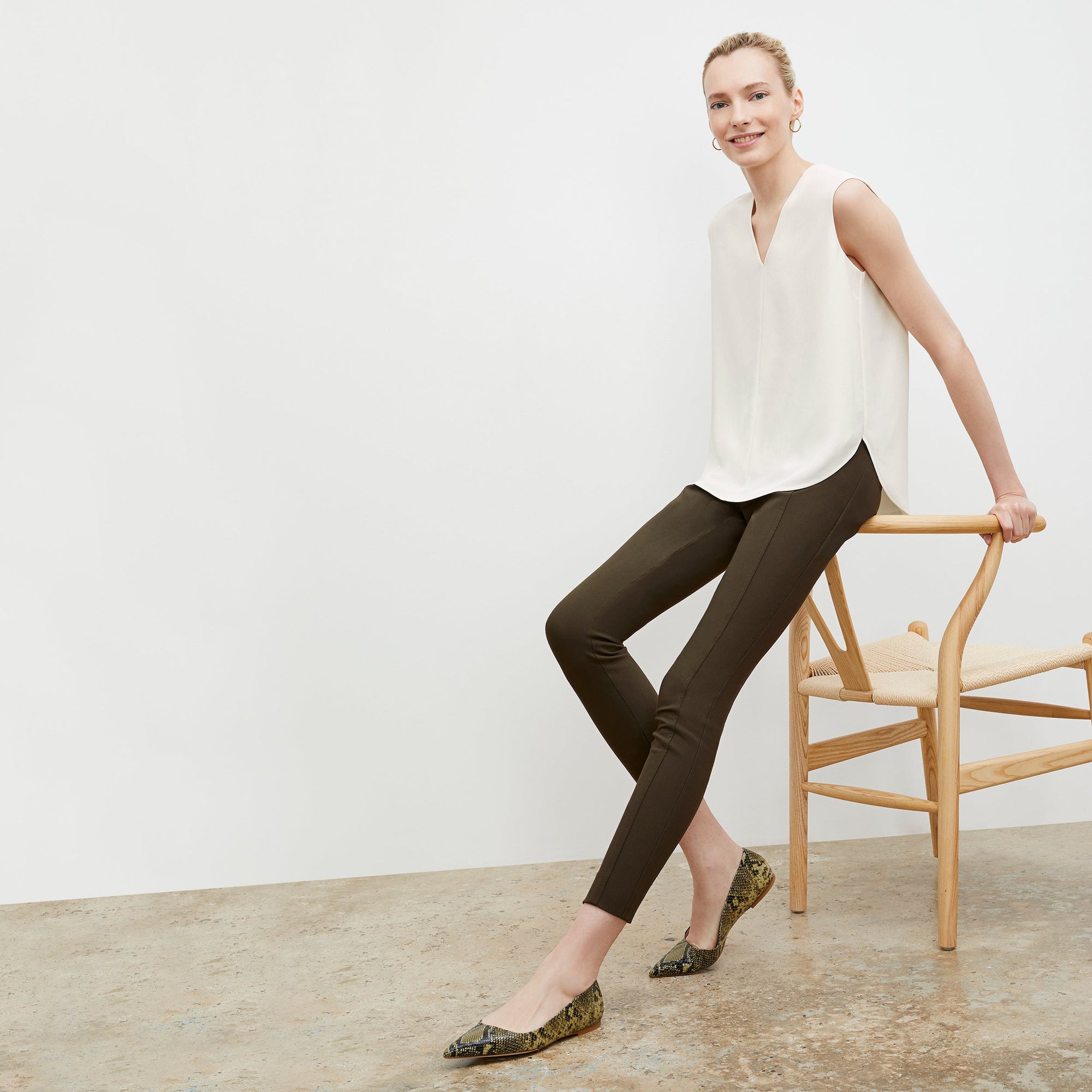 Front image of a woman standing wearing the curie pant in dark olive 