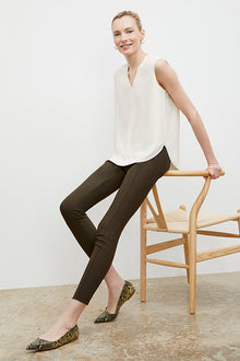 Front image of a woman standing wearing the curie pant in dark olive | Exclude