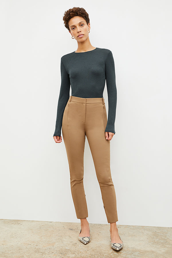 Front image of a woman standing wearing the Curie Pant—Everstretch in Saddle | Exclude | Grid
