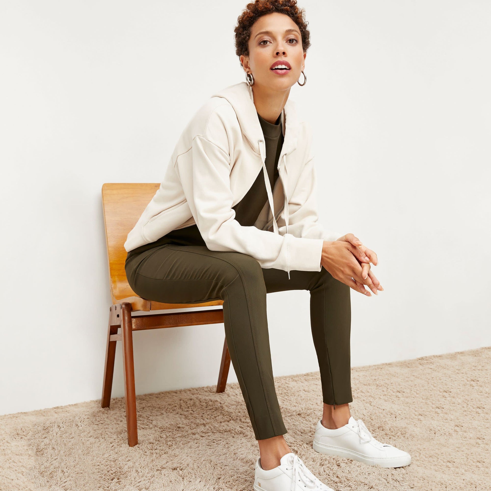 Side image of a woman standing wearing the curie pant in dark olive