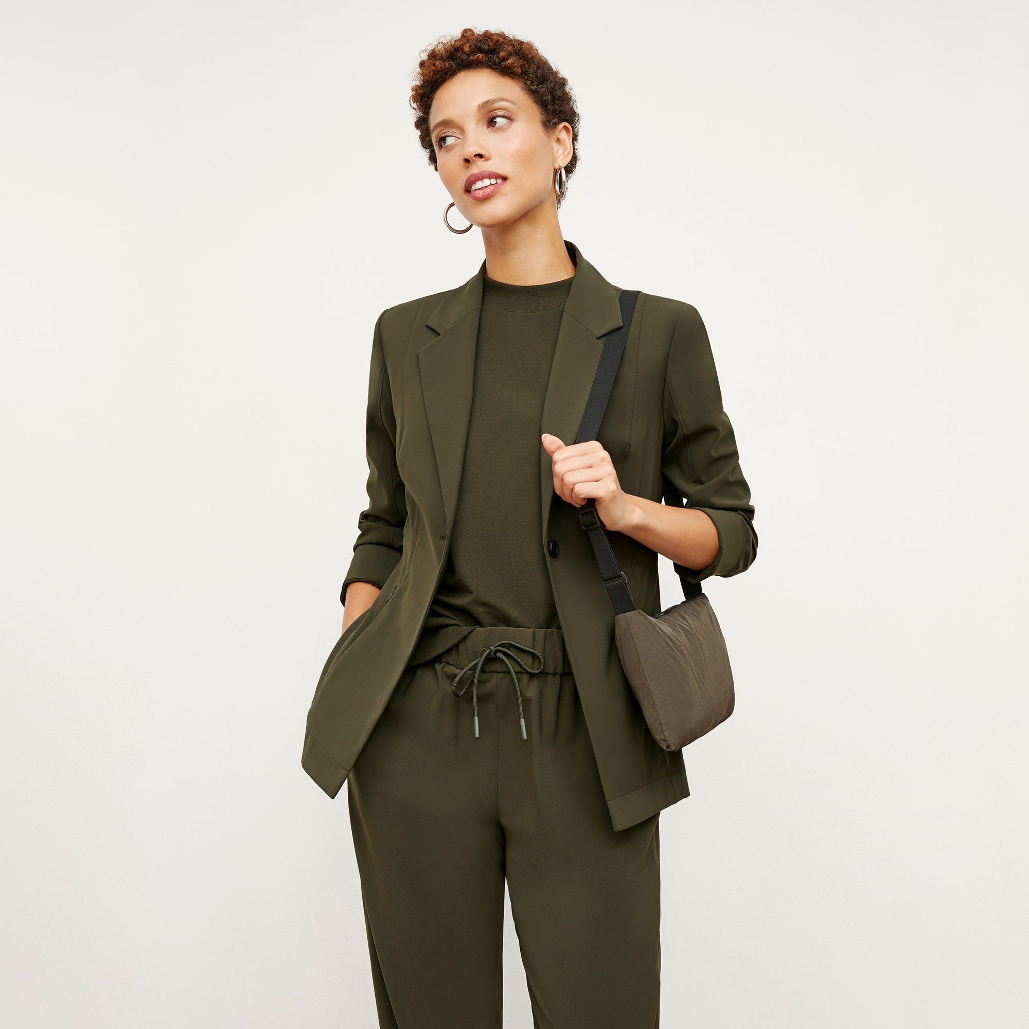 Front image of a woman standing wearing the Delaney Jogger—OrigamiTech in Olive