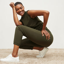 Side image of a woman standing wearing the Delaney Jogger—OrigamiTech in Olive